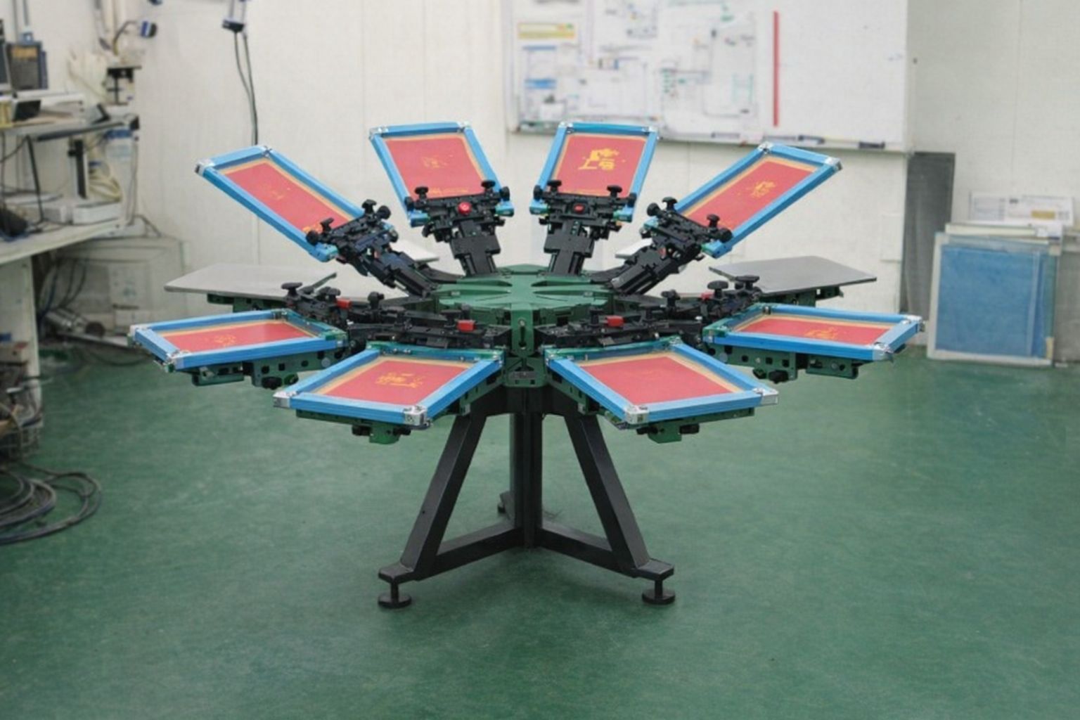 En cirkulär screentryckssnurra i en industriell verkstad för tröjor med tryck.